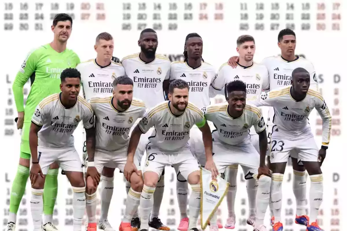 Jugadores del Real Madrid posando para una foto de equipo antes de un partido, todos vistiendo el uniforme blanco del club con el logo de su patrocinador Emirates Fly Better.