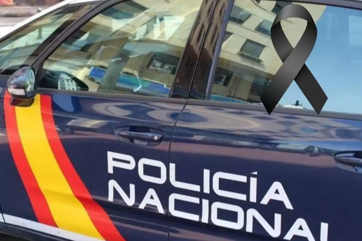 Coche de la Policía Nacional con un lazo negro en la ventana.