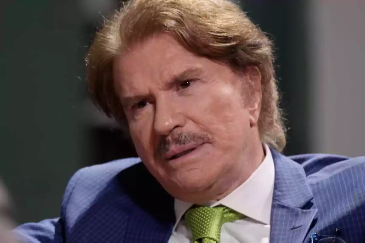 Hombre con traje azul y corbata verde en una entrevista. Hombre con traje azul y corbata verde en una entrevista.