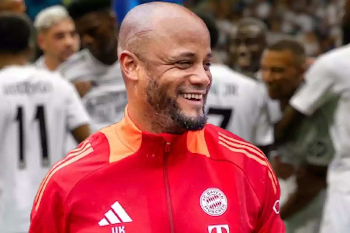 Kompany, con un grupo de jugadores de fútbol desenfocados en el fondo.