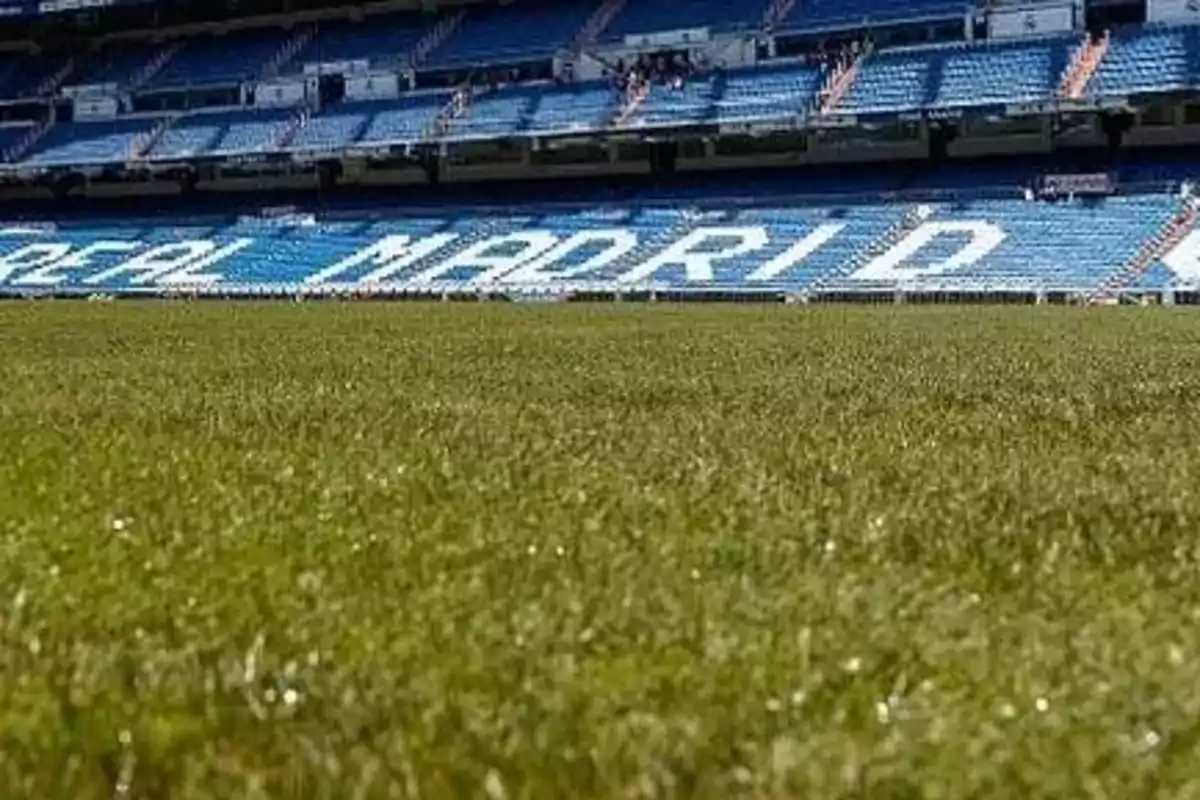 Campo de fútbol con gradas azules y letras que dicen "Real Madrid"