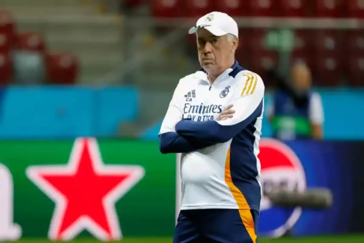 Entrenador de fútbol con uniforme del Real Madrid en el campo de juego.