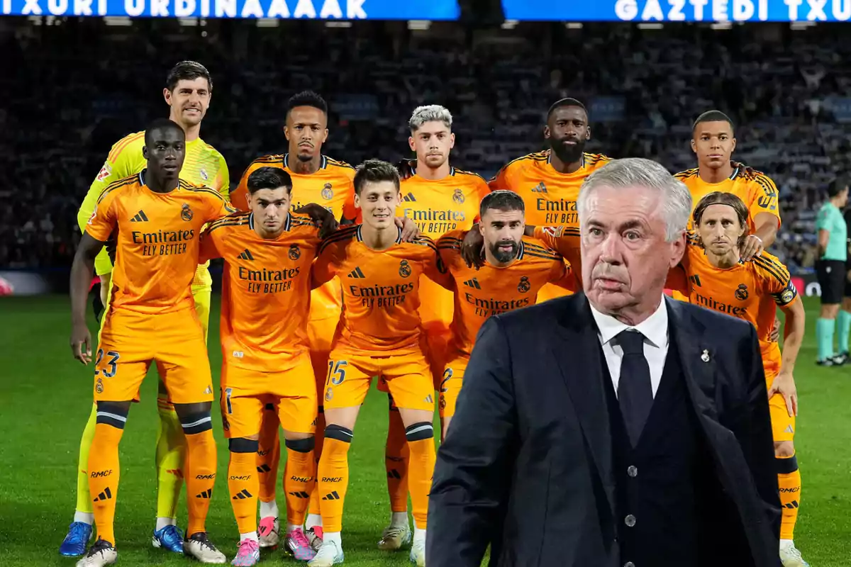 Un equipo de fútbol posando para una foto grupal en el campo, con su entrenador en primer plano.