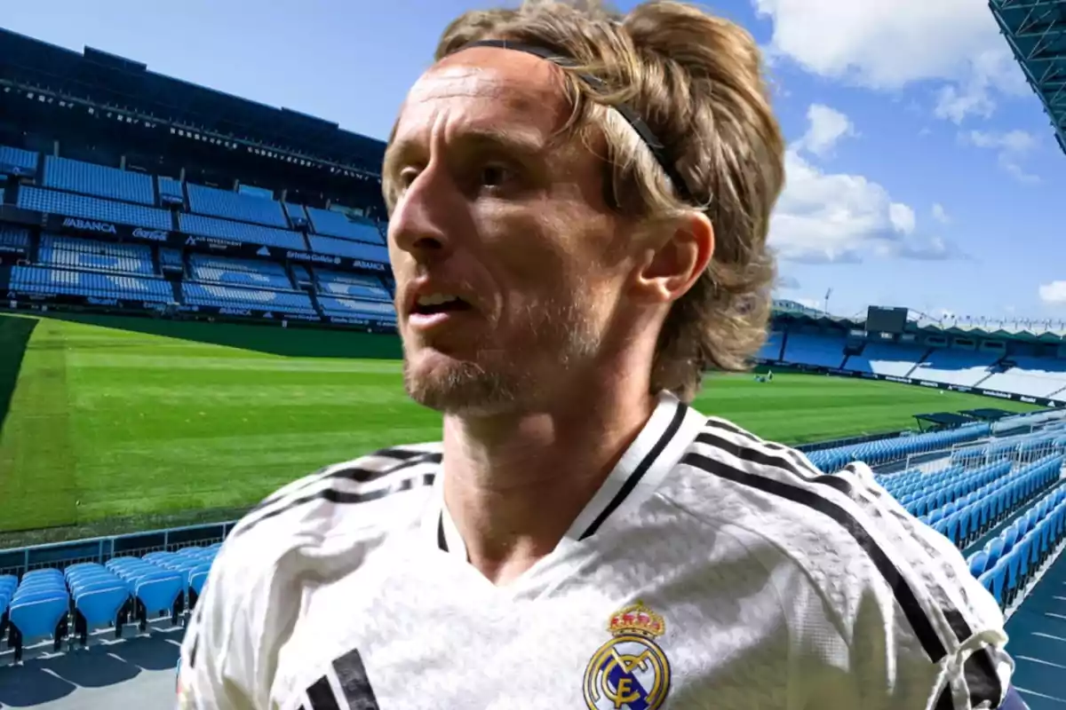 Jugador de fútbol con uniforme blanco en un estadio vacío.