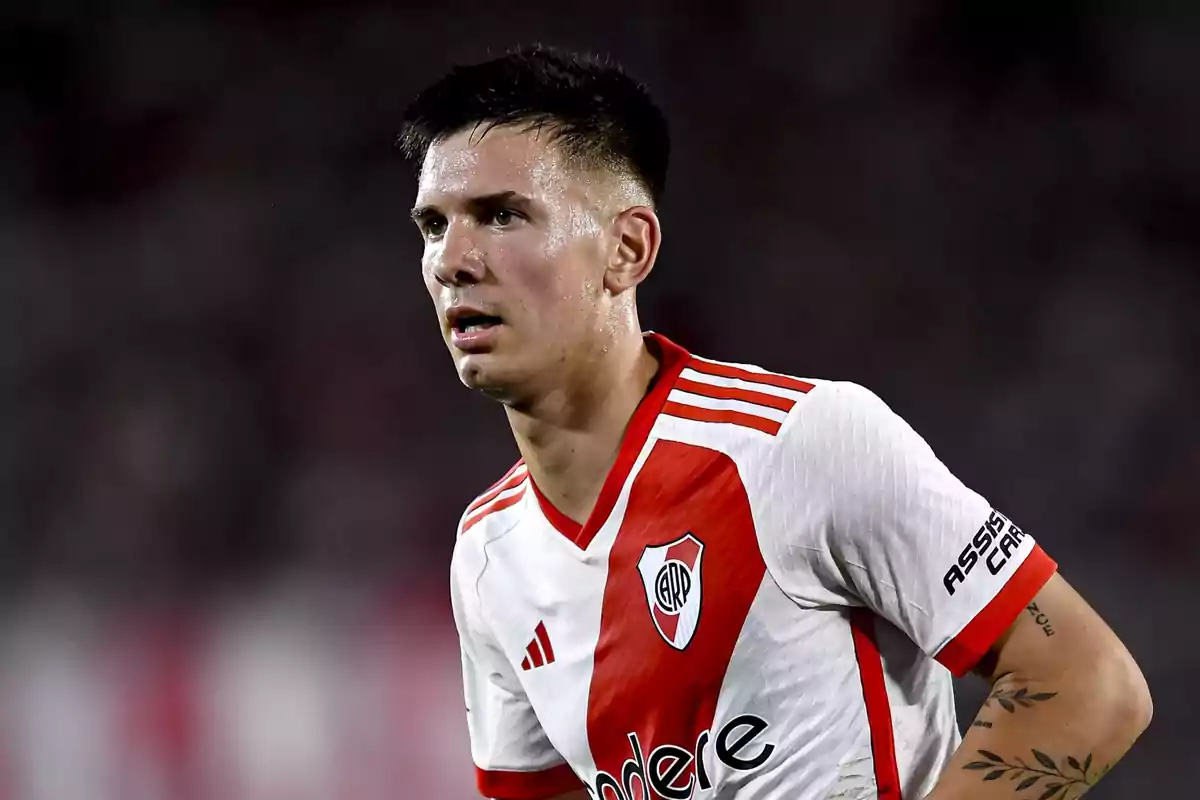 Jugador de fútbol con camiseta de River Plate en el campo de juego.