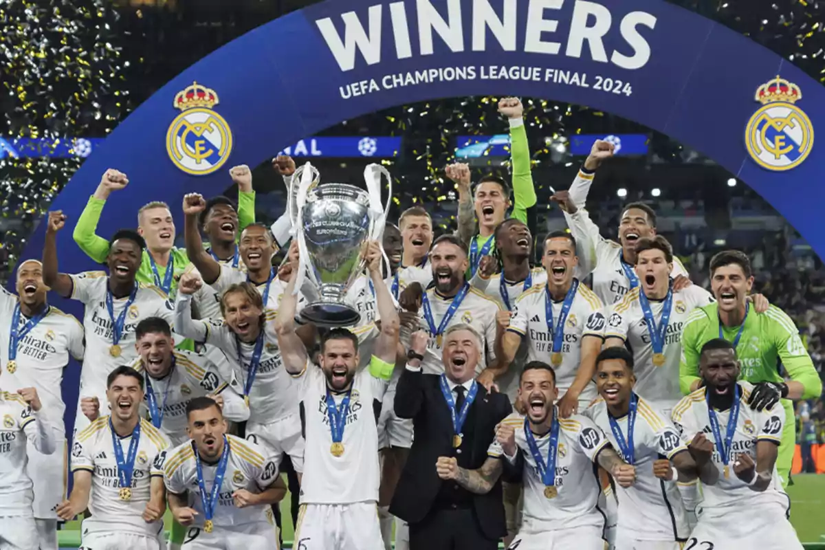 Jugadores del Real Madrid celebrando la victoria en la final de la UEFA Champions League 2024 con el trofeo y medallas.