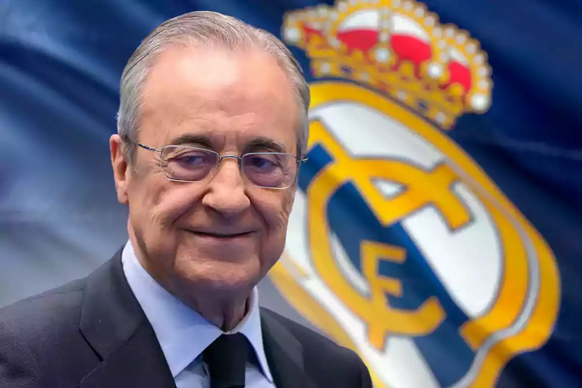 Florentino Pérez, sonriendo frente a una bandera del Real Madrid.