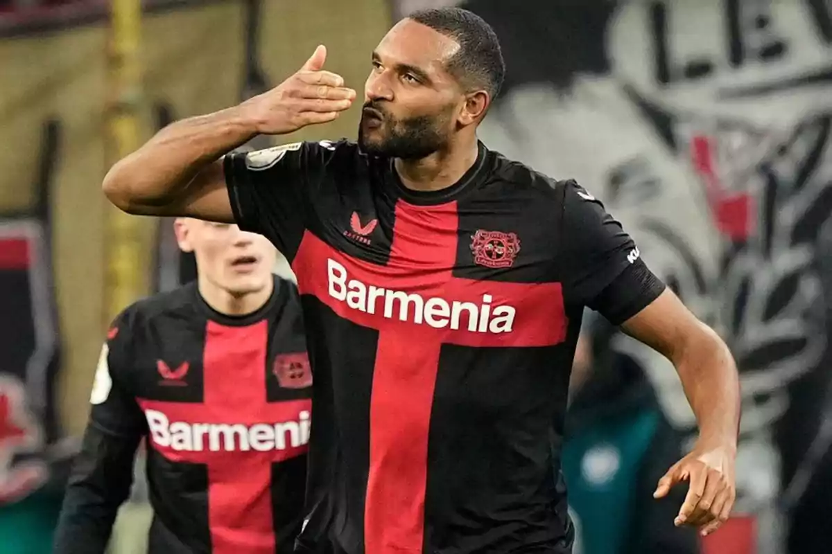 Jugador de fútbol del Bayer Leverkusen celebrando un gol con un gesto de beso en el campo.