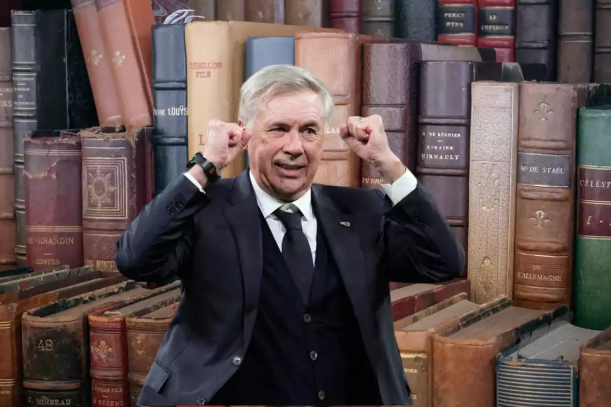 Un hombre de traje y corbata levanta los brazos en señal de victoria frente a una estantería llena de libros antiguos.