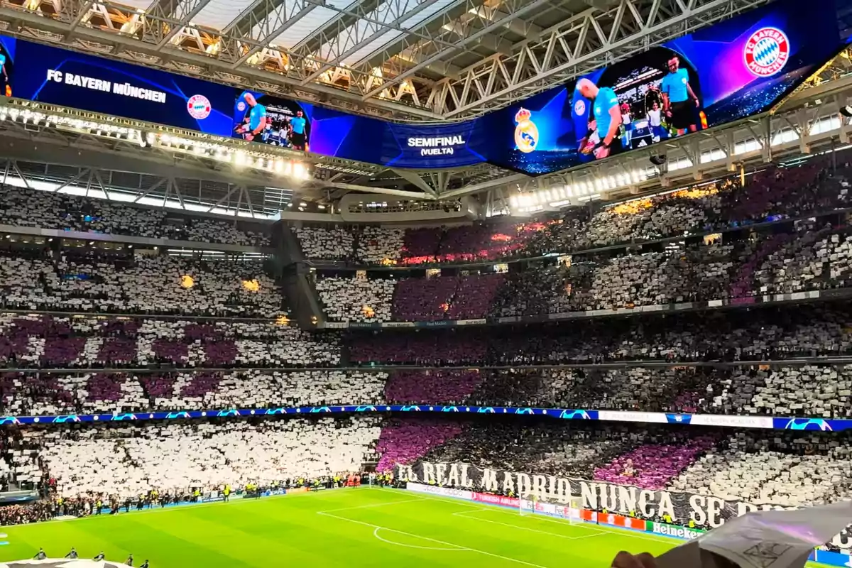 Un estadio lleno de aficionados con mosaicos en las gradas durante un partido de fútbol entre el Real Madrid y el Bayern Múnich en la semifinal de la Champions League.