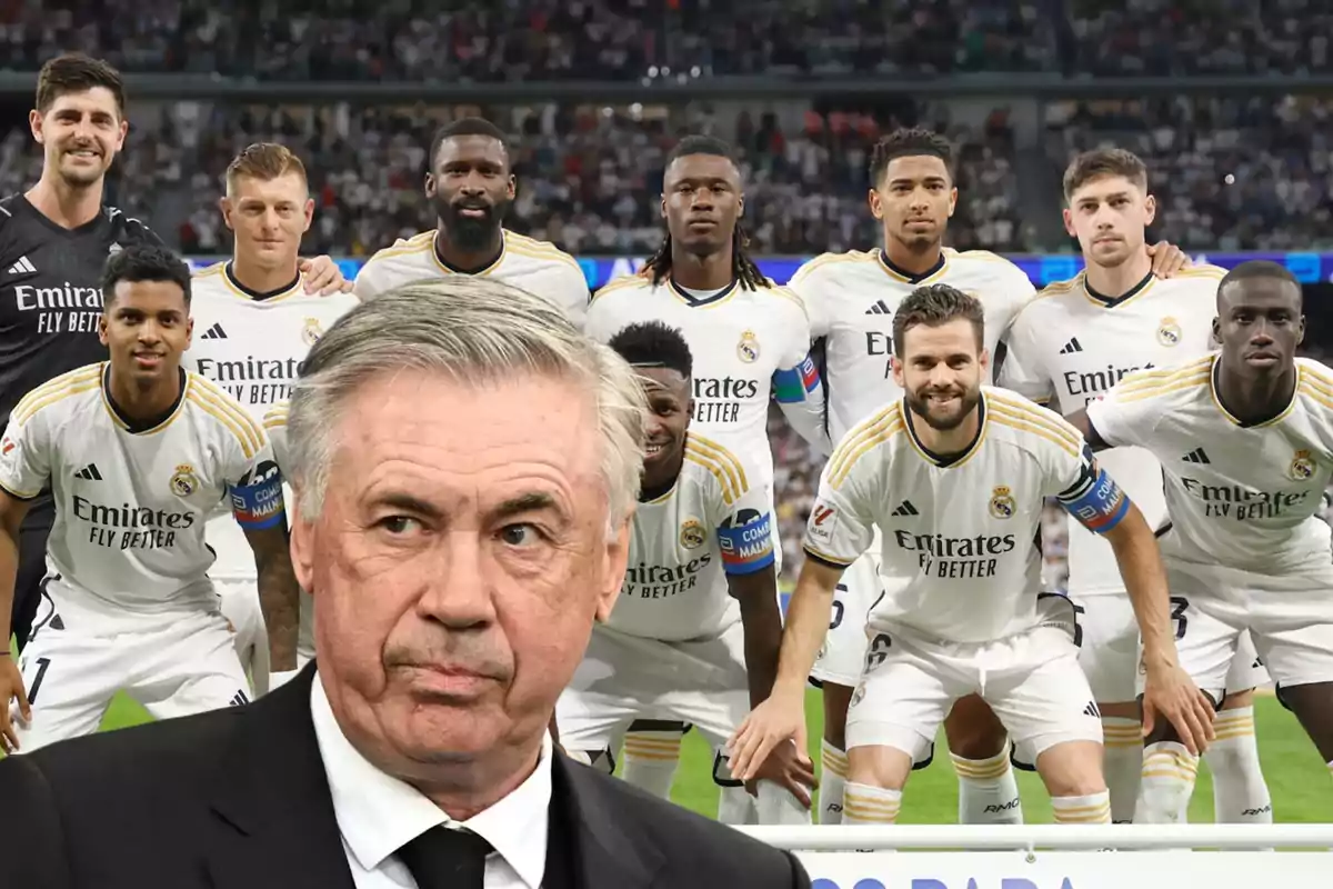 El entrenador de fútbol del Real Madrid posando con su equipo en el campo antes de un partido.