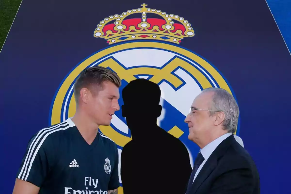 Toni Kroos y Florentino Pérez conversando y detrás de ellos la silueta en negro de un jugador, de fondo el escudo del Real Madrid en grande