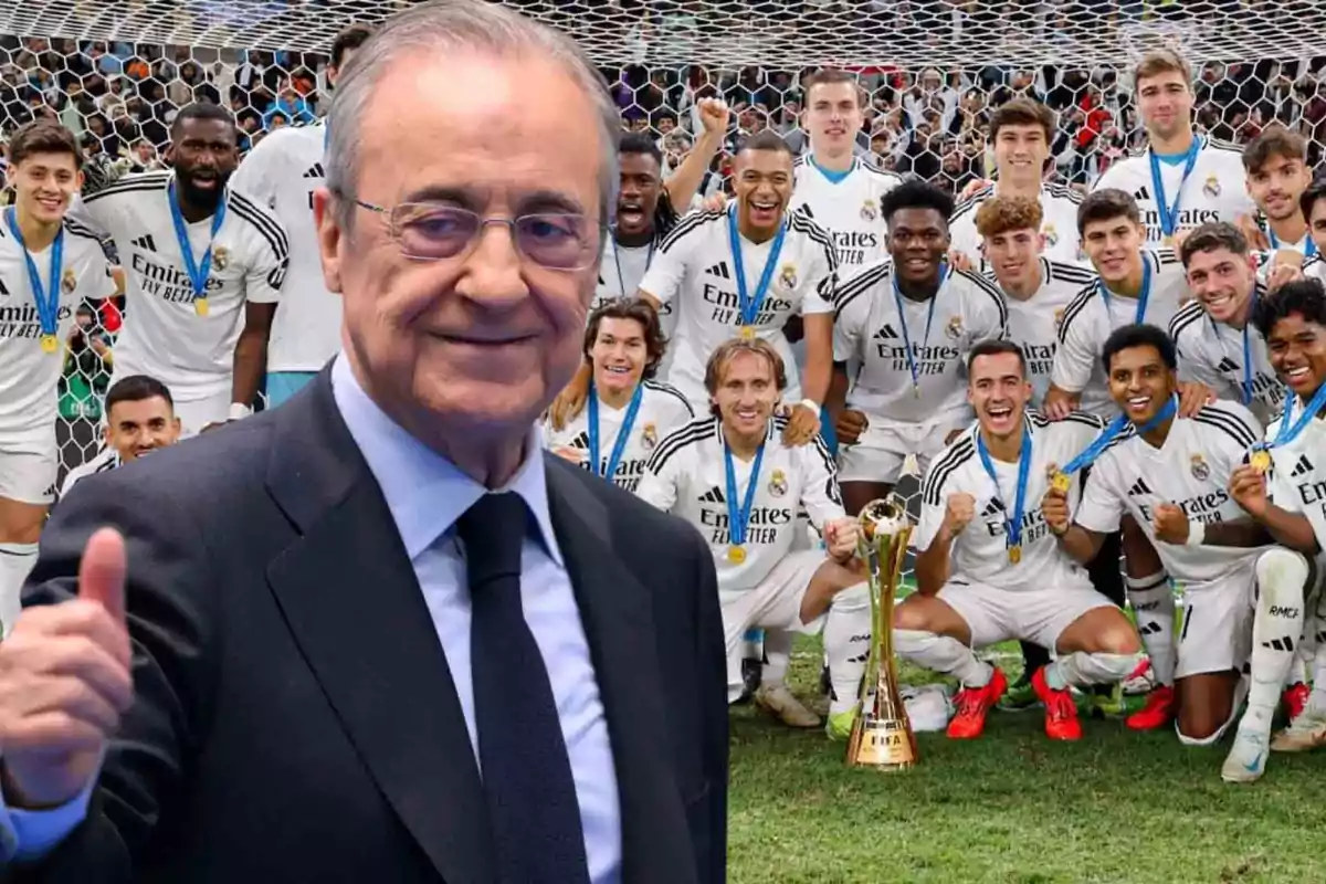 Un hombre en traje sonríe y levanta el pulgar frente a un grupo de jugadores de fútbol que celebran con medallas y un trofeo.