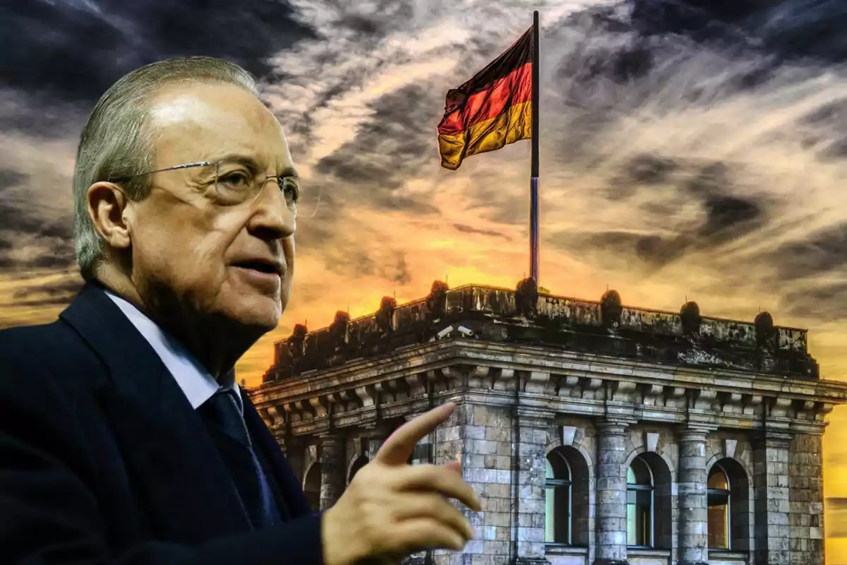 Un hombre de traje frente a un edificio con una bandera alemana ondeando al atardecer.