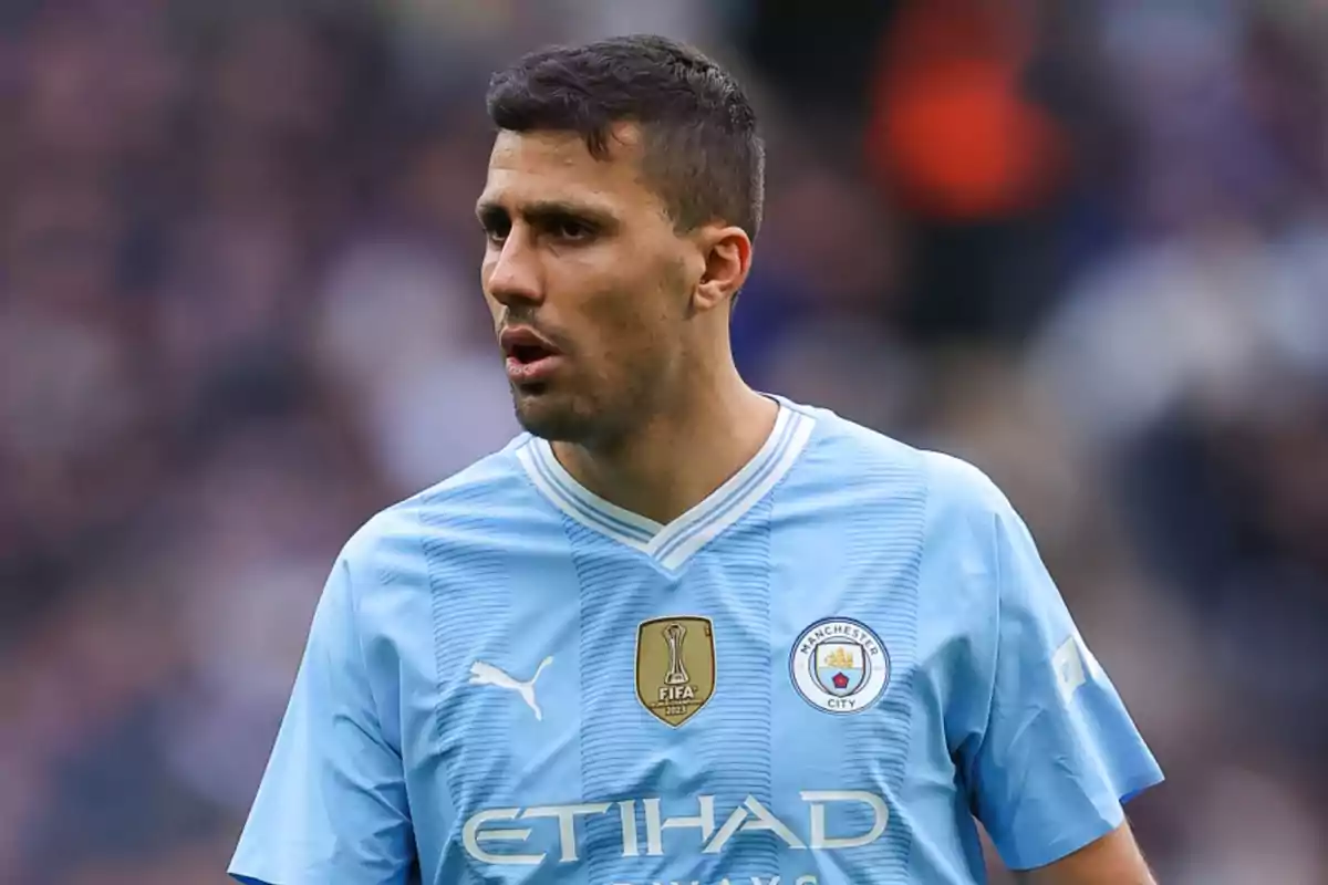 Jugador de fútbol con camiseta del Manchester City en el campo de juego.