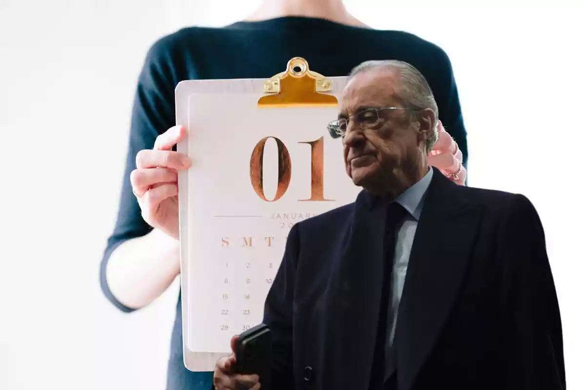 Una persona sostiene un calendario con la fecha 1 de enero mientras un hombre mayor con gafas y traje oscuro aparece en primer plano.