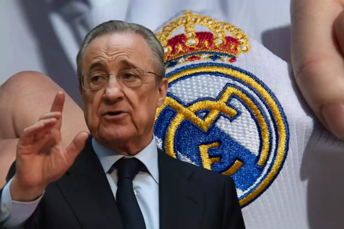 Un hombre mayor con gafas y traje oscuro gesticulando con la mano frente a un fondo con el escudo del Real Madrid.