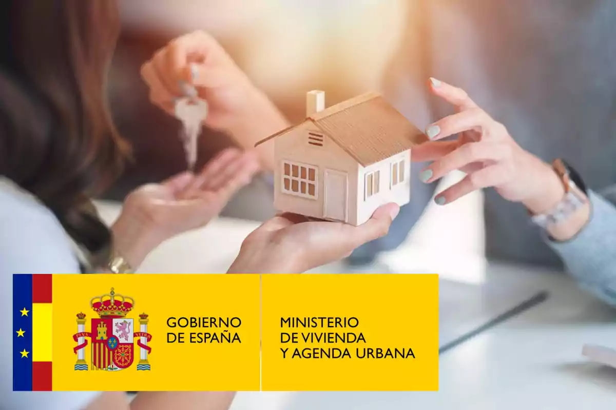 Dos personas intercambiando una casa en miniatura y una llave, con el logotipo del Gobierno de España y el Ministerio de Vivienda y Agenda Urbana en la parte inferior.