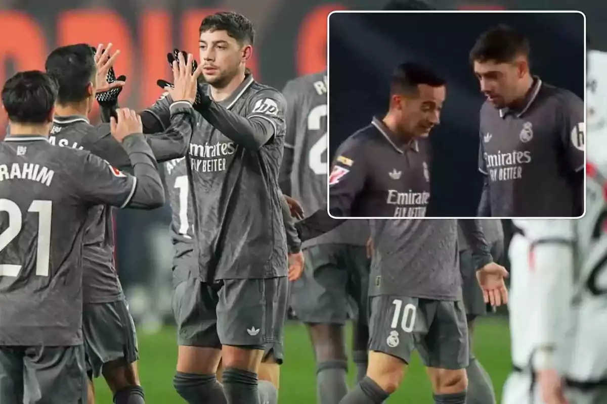 Jugadores de fútbol del Real Madrid celebran en el campo con uniformes grises.