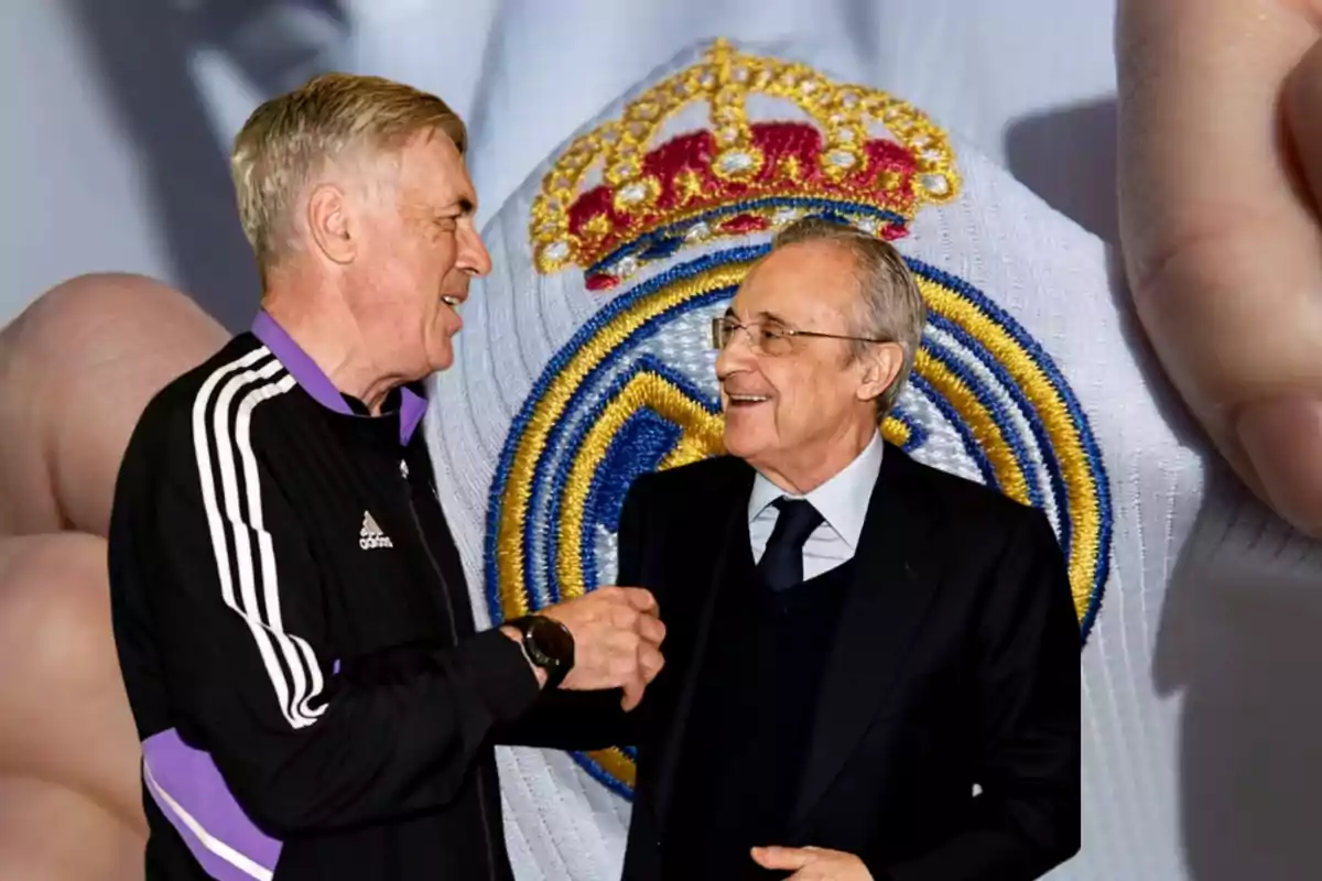 Dos hombres conversando y sonriendo con el escudo del Real Madrid de fondo.