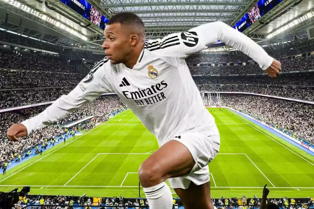 Jugador de fútbol con uniforme blanco en un estadio lleno de espectadores.