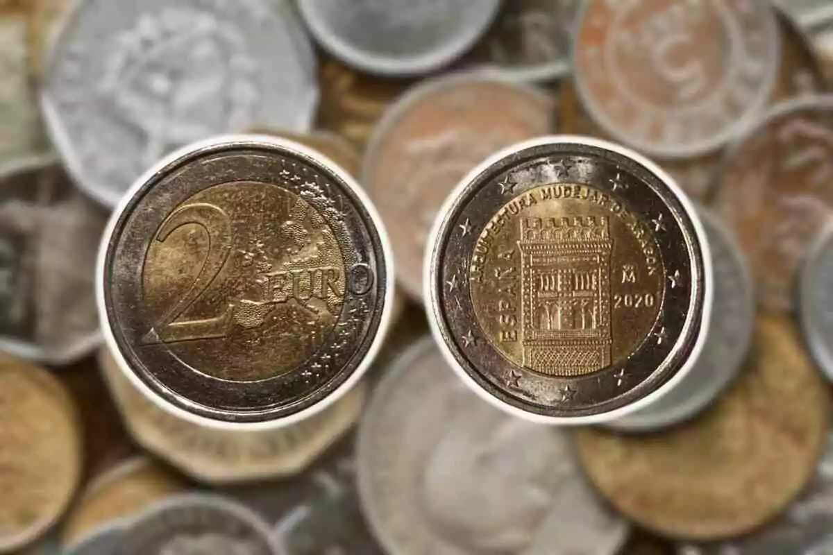 Primer plano de dos monedas de dos euros con fondo de otras monedas desenfocadas. Primer plano de dos monedas de dos euros con fondo de otras monedas desenfocadas.