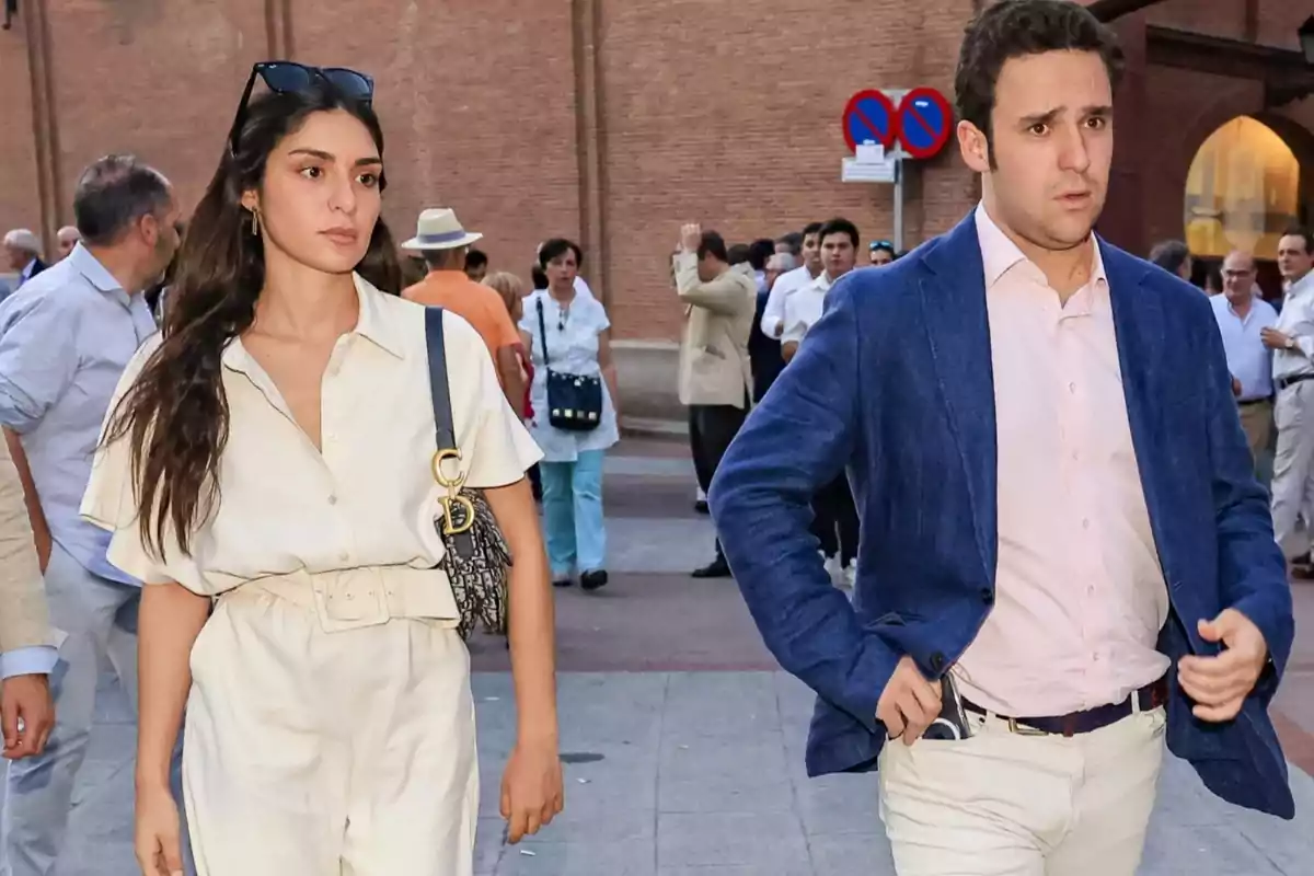 Dos personas caminando en una calle concurrida, una mujer con un conjunto claro y un bolso, y un hombre con chaqueta azul y camisa clara. Dos personas caminando en una calle concurrida, una mujer con un conjunto claro y un bolso, y un hombre con chaqueta azul y camisa clara.