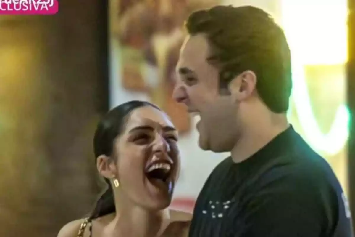 Dos personas riendo juntas en un ambiente iluminado. Dos personas riendo juntas en un ambiente iluminado.