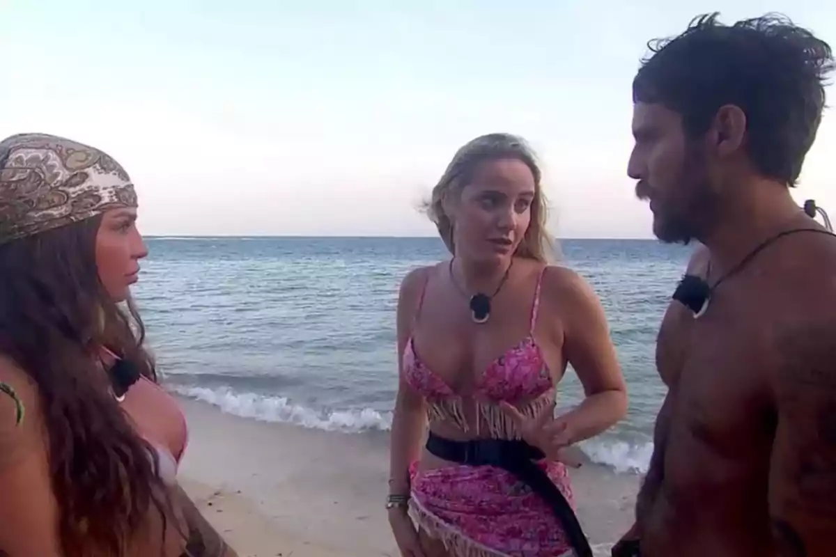 Tres personas conversando en la playa junto al mar. Tres personas conversando en la playa junto al mar.
