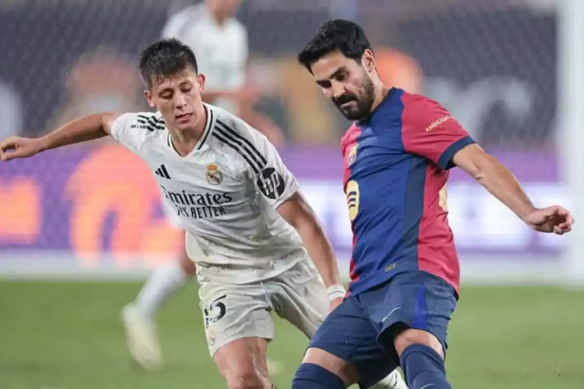 Dos jugadores de fútbol compitiendo por el balón en un partido.