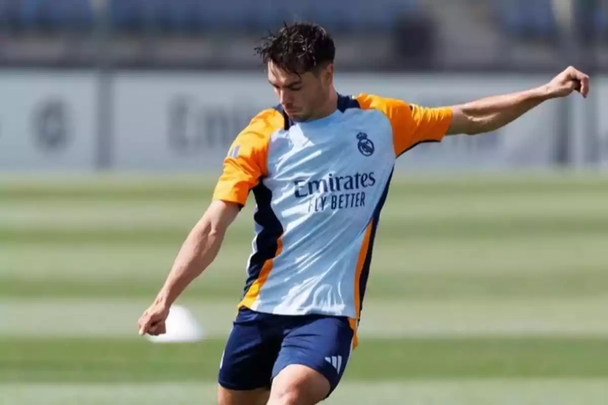 Jugador de fútbol entrenando en el campo con uniforme del Real Madrid.