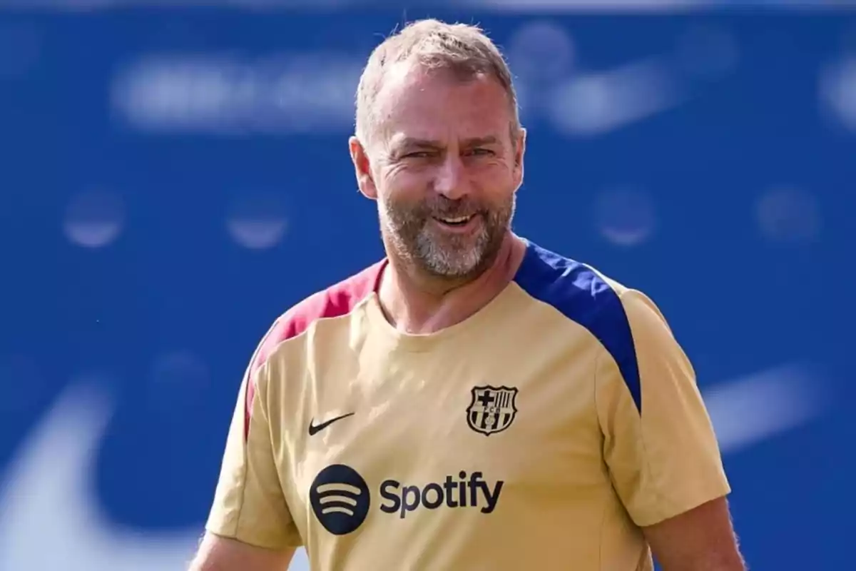 Un hombre sonriente con una camiseta de entrenamiento del FC Barcelona.