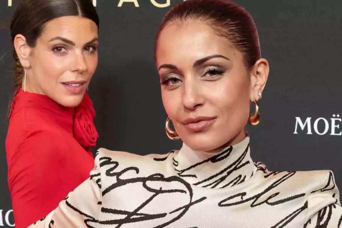 Dos mujeres posando en un evento con fondo negro y letras blancas, una lleva un vestido rojo y la otra un vestido con estampado de letras.