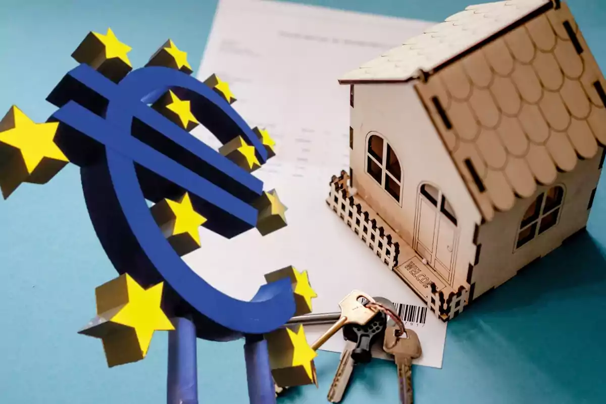 Símbolo del euro junto a una casa en miniatura y un juego de llaves sobre un documento.