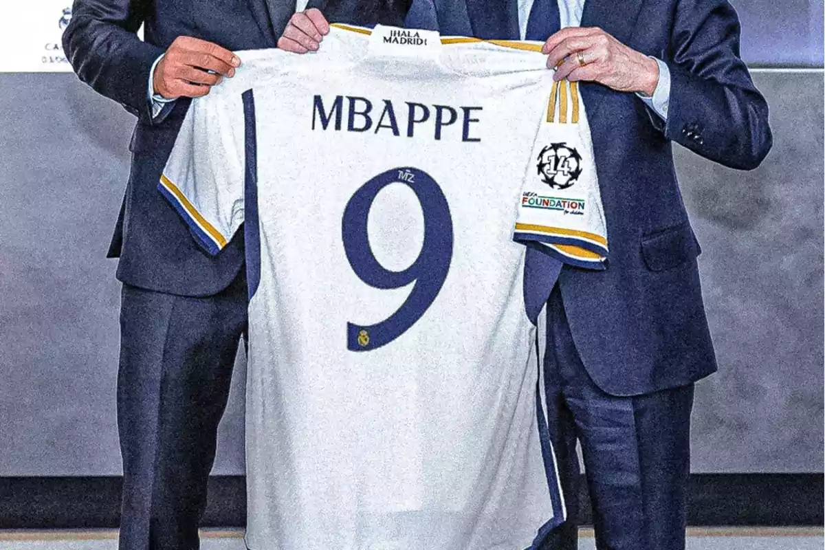 Dos personas sostienen una camiseta de fútbol con el nombre "Mbappé" y el número 9.