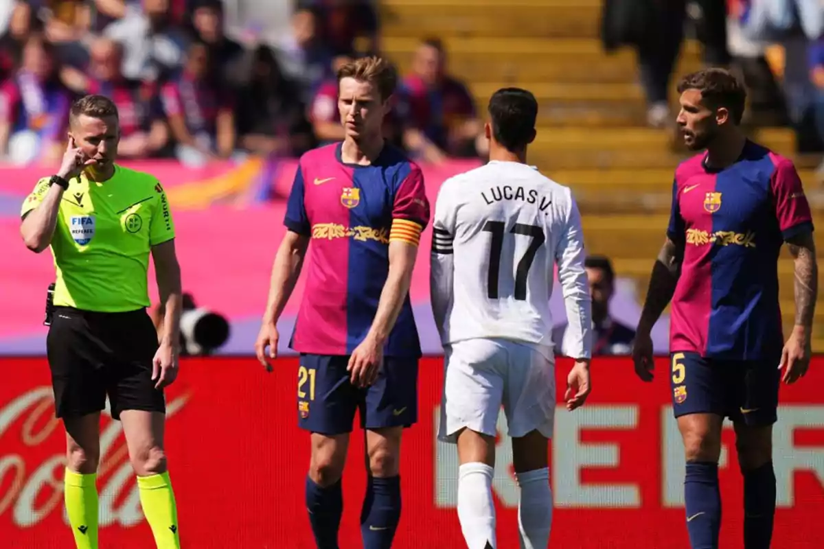 Un árbitro y tres jugadores de fútbol en el campo durante un partido. Un árbitro y tres jugadores de fútbol en el campo durante un partido.