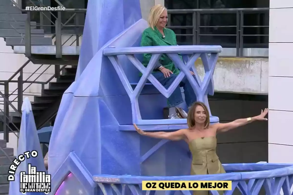 Dos personas están en una estructura azul con forma de castillo, una está sentada y la otra de pie con los brazos extendidos, hay un texto en la parte inferior que dice Dos personas están en una estructura azul con forma de castillo, una está sentada y la otra de pie con los brazos extendidos, hay un texto en la parte inferior que dice