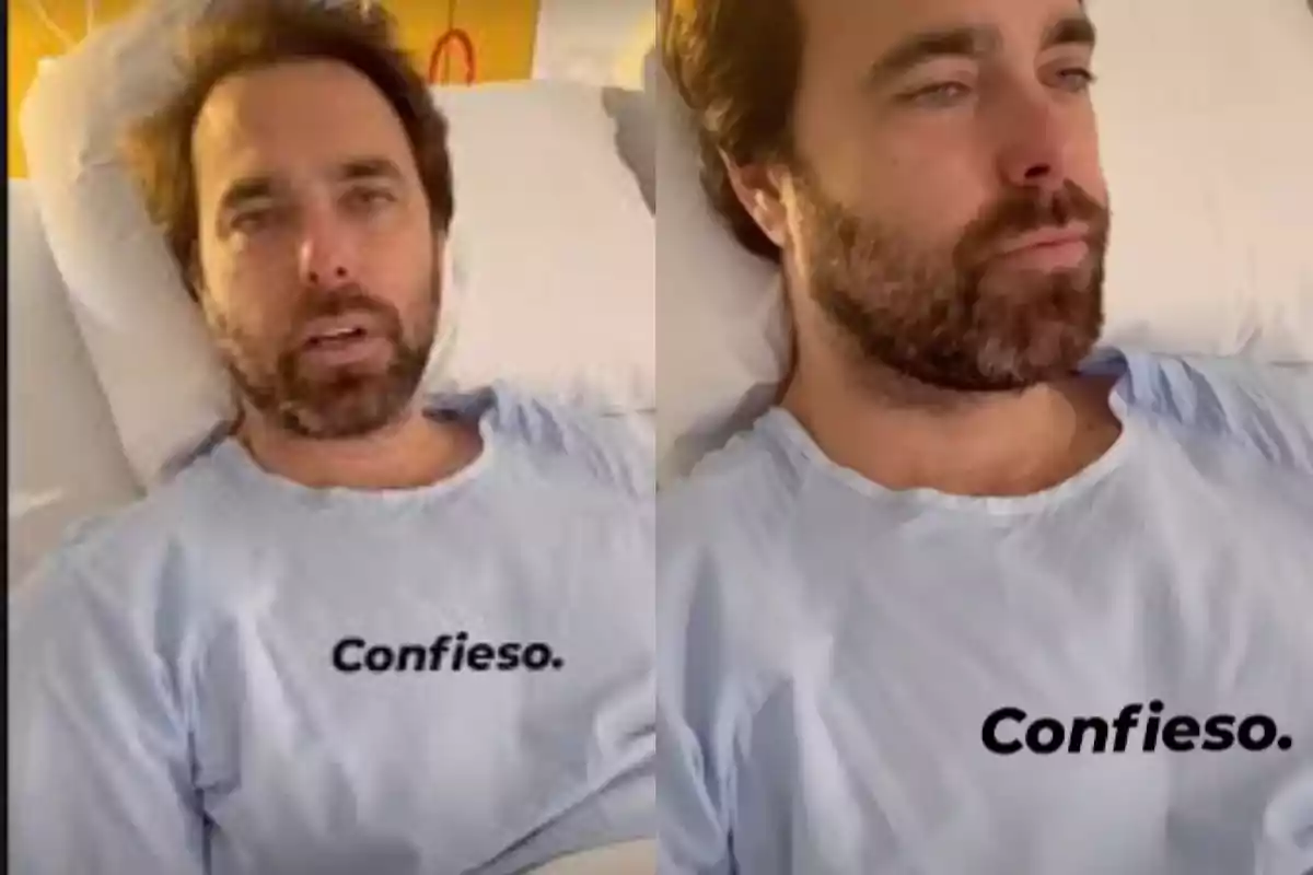 Un hombre con barba está acostado en una cama de hospital, vistiendo una bata azul que tiene la palabra 