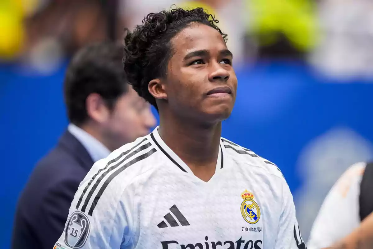 Un jugador de fútbol con la camiseta del Real Madrid mirando hacia arriba.