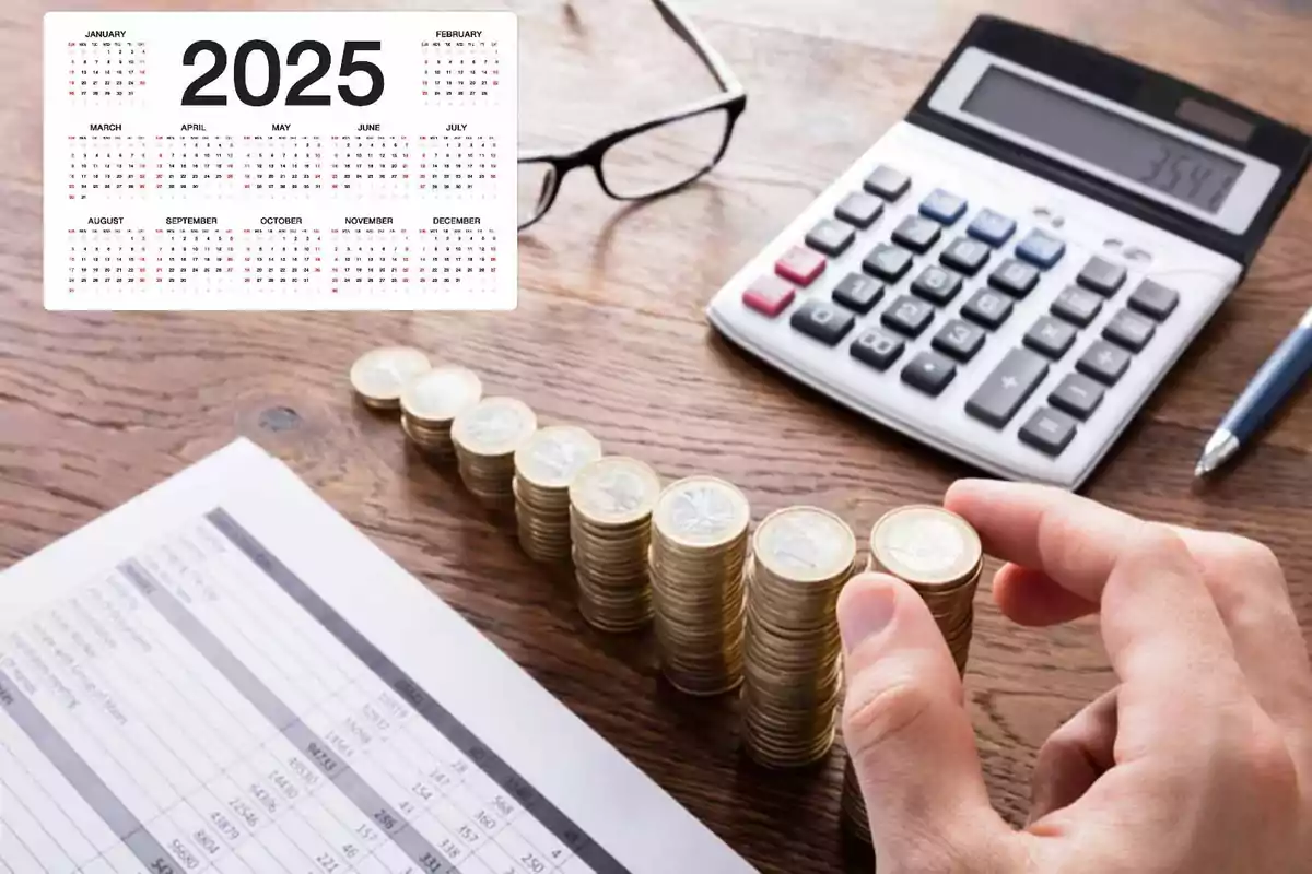 Una mano apilando monedas junto a una calculadora y un calendario del año 2025 sobre una mesa de madera.