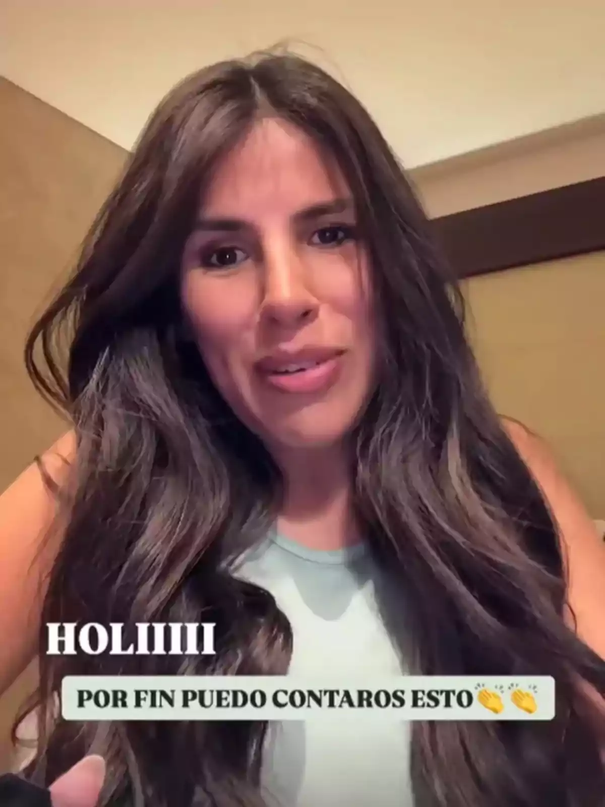 Una persona con cabello largo y oscuro sonríe a la cámara, con texto en la imagen que expresa emoción por compartir una noticia. Una persona con cabello largo y oscuro sonríe a la cámara, con texto en la imagen que expresa emoción por compartir una noticia.