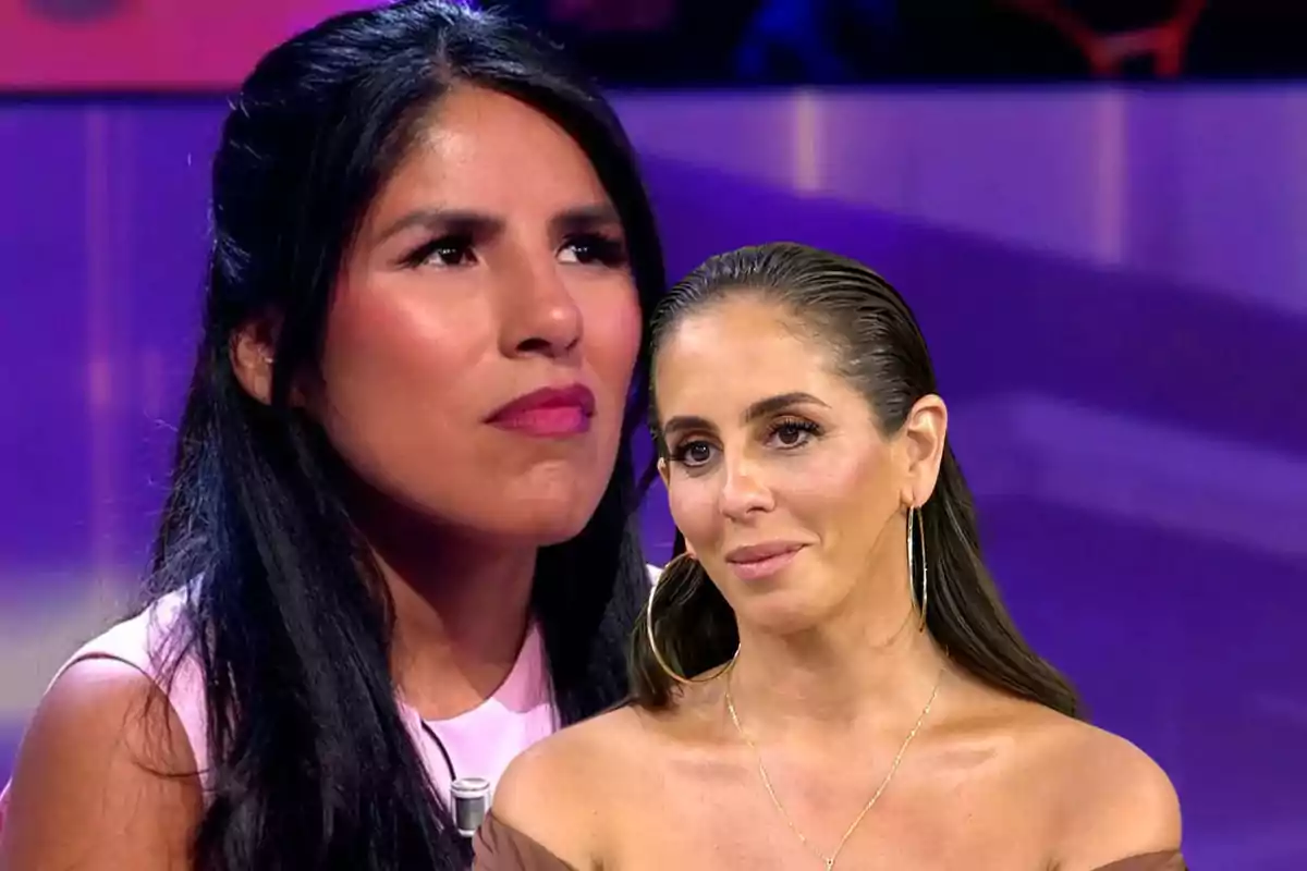 Dos mujeres en un plató de televisión con expresiones serias y fondo morado.