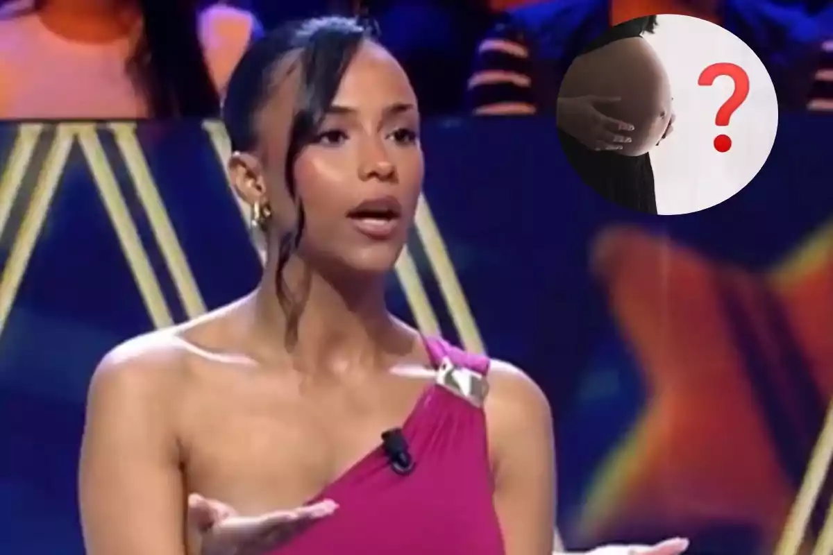 Una persona con un vestido rosa está hablando en un programa de televisión, mientras en la esquina superior derecha se muestra una imagen de una barriga de embarazada con un signo de interrogación.