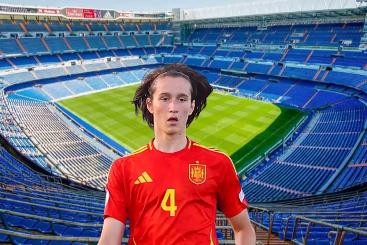 Un jugador de fútbol con la camiseta de la selección española en un estadio vacío.