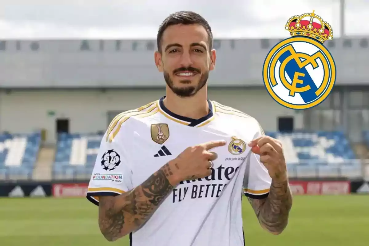 Un jugador de fútbol con la camiseta del Real Madrid señalando el escudo del equipo.