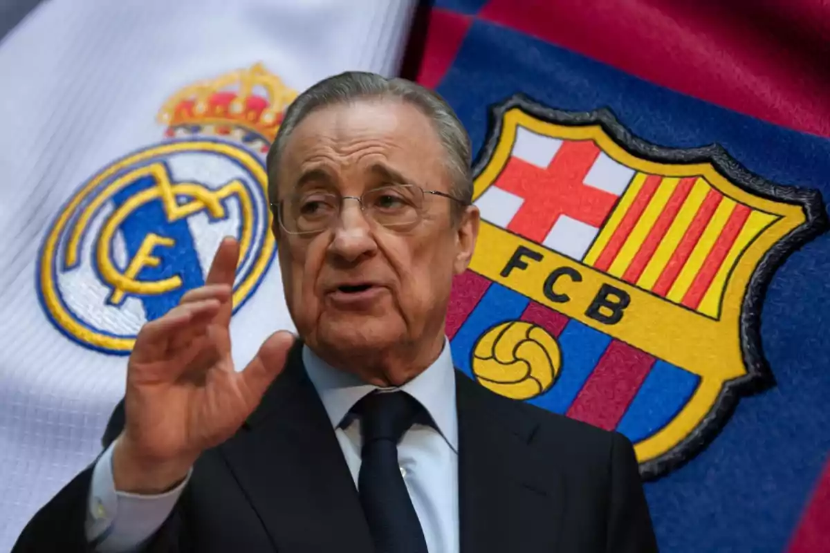 Un hombre con gafas y traje oscuro gesticulando con la mano frente a los escudos del Real Madrid y el FC Barcelona.