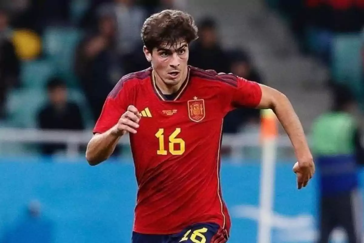 Jugador de fútbol con camiseta roja número 16 en acción durante un partido.