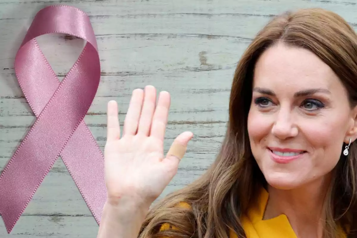 Kate Middleton sonriente saluda con una mano arriba, y de fondo un lazo rosa contra el cáncer