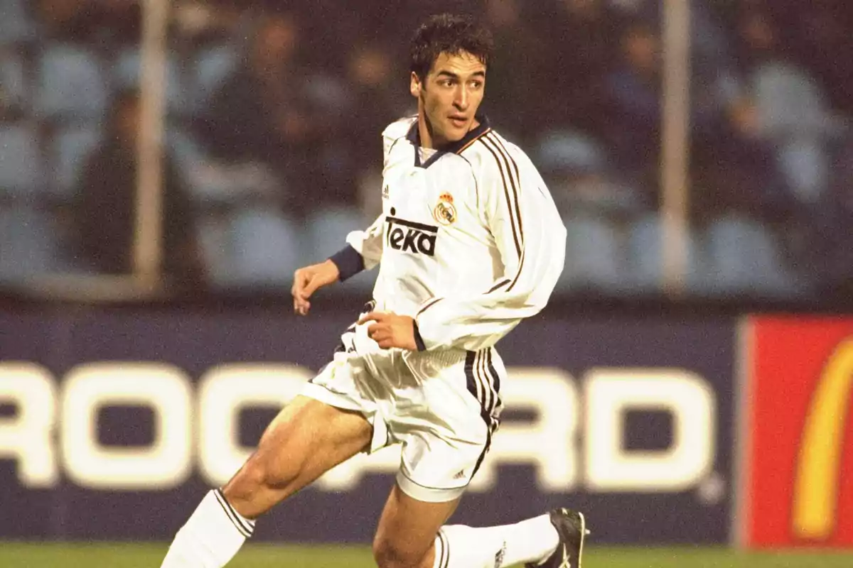 Raúl González con uniforme blanco del Real Madrid en acción durante un partido.