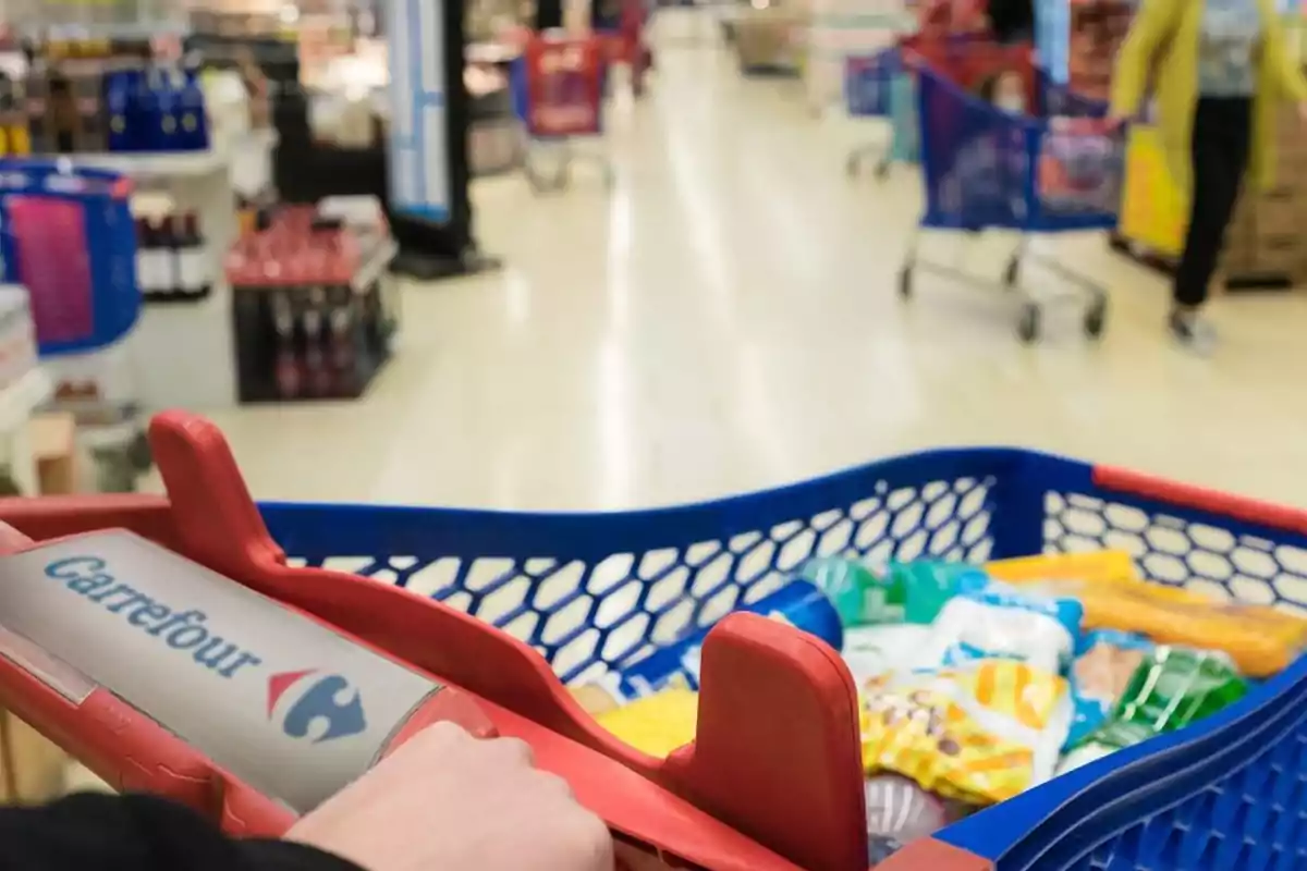Un carrito de compras de Carrefour lleno de productos en un supermercado. Un carrito de compras de Carrefour lleno de productos en un supermercado.